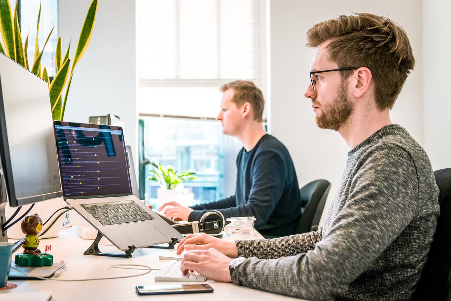 Two people working at desks in an office